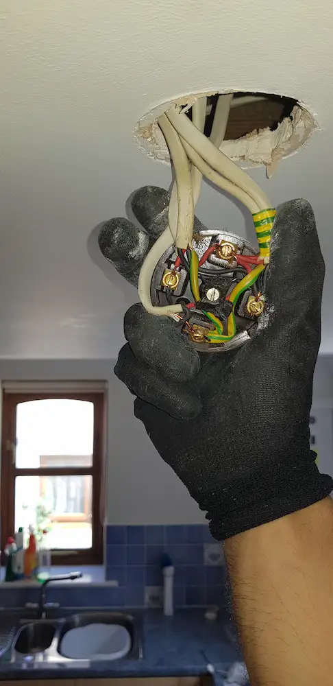 Electrician checking connections during an EICR inspection in East Devon